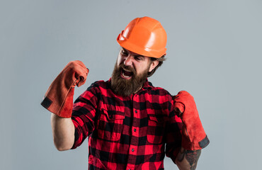 handsome bearded guy with beard and moustache wear gloves, building