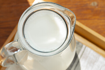 Glass jar of milk on old wooden table