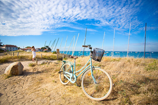 Vélo et touriste sur l'île de Noirmoutier en Vendée, bord de mer et plage sauvage.