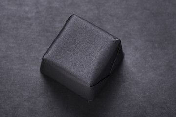 Black gift wrapped pack, package on dark backgroound