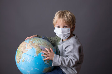 Cute toddler child, boy, hugging big globe, isolated image