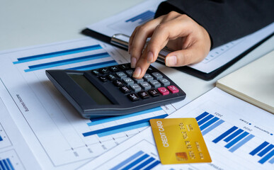 Businessmen use a calculator to calculate income and expenses in order to manage budgets to pay off...
