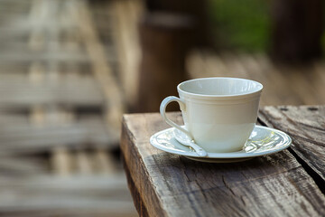 cup of coffee on wood chair with nature view behind