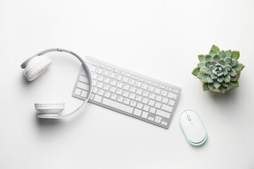 Composition with computer keyboard, mouse and headphones on white background