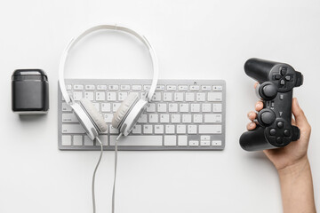 Female hand with computer keyboard and different modern devices on white background