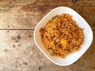 indonesian instant noodle served in white bowl with copy space.
