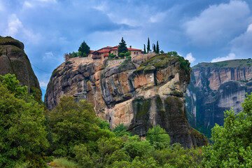 Fototapeta na wymiar Close view of clifftop Eastern Orthodox monastery of Holy Trinity or Agia Triada in famous Meteora valley, Greece, UNESCO World Heritage, cloudy sky