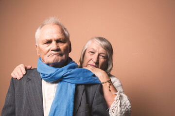 Dramatic light portrait of elderly couple; old man and woman posing together at home; with copyspace for text