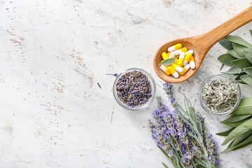 Wooden spoon with plant based pills on light background