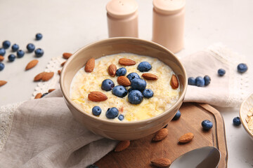 Bowl with tasty oatmeal and blueberry on table