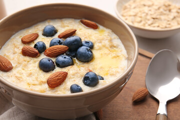 Bowl with tasty oatmeal and blueberry on table