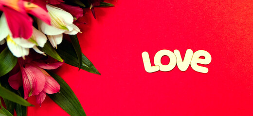 Banner. The word love in English is made of wood on a red background. On the left are flowers. Concept: Valentine's Day, March 8, wedding. Minimalism.