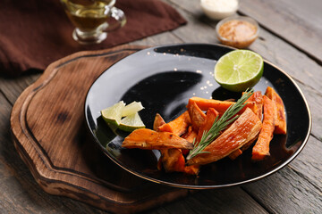 Plate with tasty cooked sweet potato on wooden background