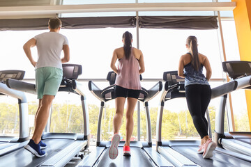Obraz na płótnie Canvas Young people training on treadmills in gym