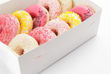 Sweet donuts in box on white background
