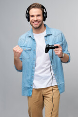 young man in casual jeans shirt holding joystick or gamepad playing game © Anatoly Repin