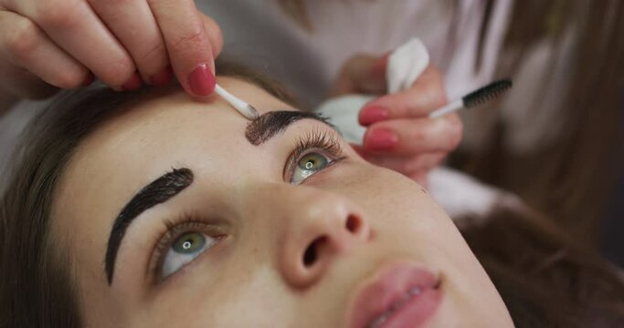 Caucasian woman lying down having her eyebrows dyed