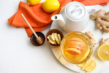 Board with cup of aromatic tea with lemon, ginger and honey on table