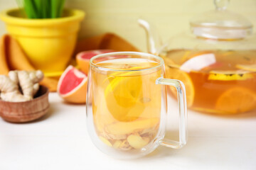 Cup of healthy tea with lemon and ginger on table