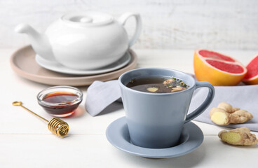 Cup of aromatic tea with lemon, honey and ginger on table