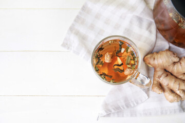 Cup of delicious tea with ginger on table