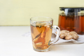 Cup of delicious tea with ginger on table