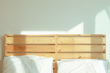 Fototapeta na wymiar Loft bedroom with white bed in soft sunlight of winter morning.
