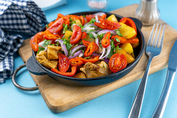 Pork ojakhuri with vegetables. Meat, potatoes, onions, herbs, peppers cooked and served in a skillet. A dish of Georgian cuisine. Meat food, lunch, dinner on the table.