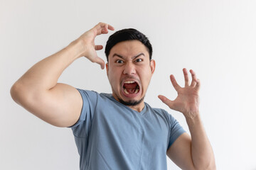 Angry and mad face of Asian man in blue t-shirt on isolated background.