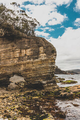 wild Tasmanian landscape during a hike to Fossil Cove with natural rock archway