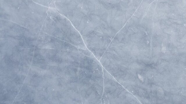 Blue cracked ice close-up, natural background, aerial view.