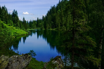 beautiful reflection from the sky and trees in a mountain lake