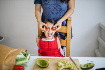 Happy mother and daughter playing with their food