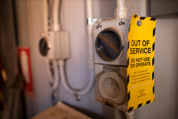 Safe workplaces practices yellow out of service warning tag placing on damaged faulty goods...