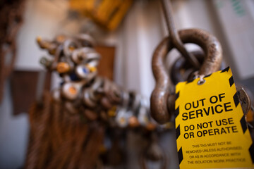 Safety workplaces yellow out of service tag attached on faulty damage defect of 4.5 ton shackle...