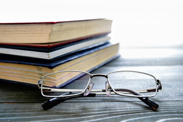 Glasses and stack of hardcover books