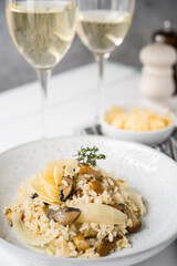 Risotto with porcini mushrooms and parmesan on a light background, selective focus