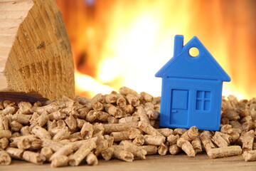 a wood stove with pellets, wood and a toy house