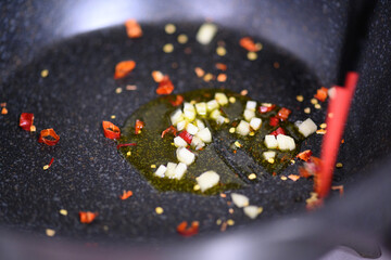 ニンニク・鷹の爪を油で炒める