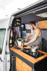 Man cooking inside his camper van
