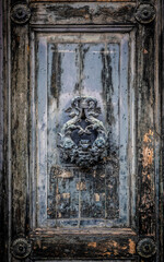 Door handle and door knocker against wooden texture in Venice, italy. 