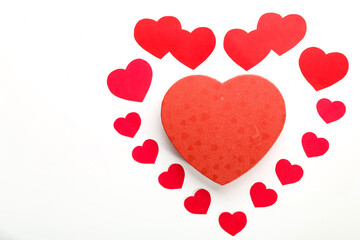 A large heart made of paper hearts laid out on a white background in the middle of a cardboard heart.