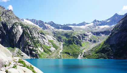 Landschaft am Gelmersee in der Schweiz. Rundwanderung  um den Gelmer See mit türkisblauem Wasser und schneebedeckten Bergen..