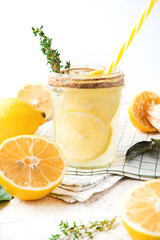 Fototapeta premium Homemade refreshing lemonade, detox drink with lemon and herbs on a light background