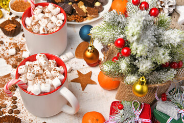 sweet food top view background for merry christmas or new year holiday decoration - chocolate candies, tangerines, cookies, marshmallow and cocoa latte on white wood