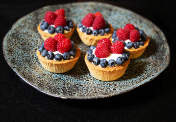Basket with cream, blueberries and raspberries
