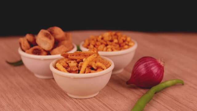 bhakharvadi and mix chavan or chana dal with green chilli peppers on wooden teble,Made of Gram Flour And Mixed With Dry Fruits on wooden background,Chivda, Farsan, Namkin,