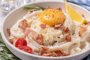 Classic carbonara pasta with fried bacon, parmesan cheese and egg yolk.
