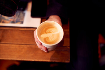 Close Up Of Hand Holding Takeaway Cup Of Coffee