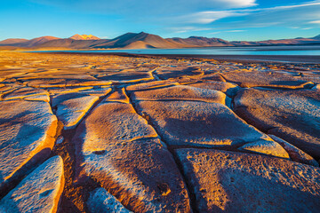 Landscape with the solidified lava field Piedras Rojas, salt lake and volcanoes in the high Andes...